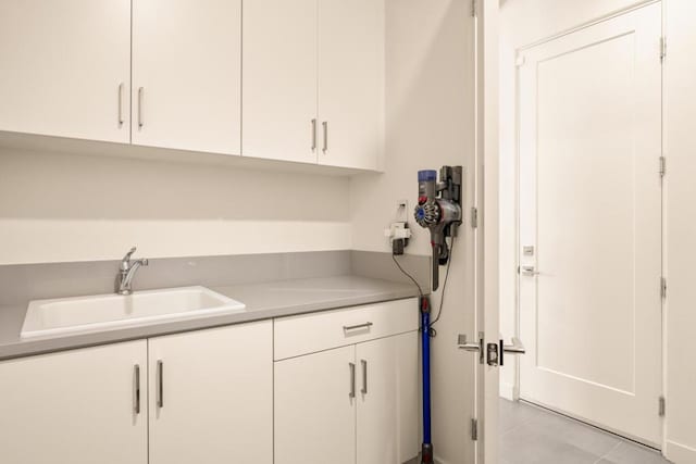 clothes washing area with sink and light tile patterned floors