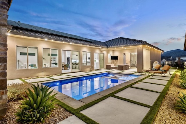 pool at dusk featuring an outdoor hangout area and a patio