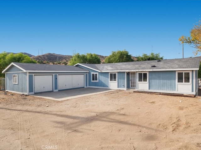 ranch-style home featuring a garage and a mountain view