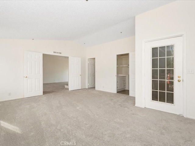 carpeted empty room featuring vaulted ceiling