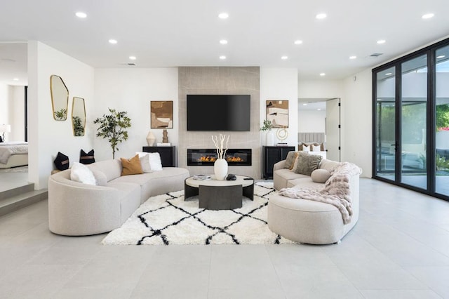 living room with light tile patterned floors, a fireplace, and floor to ceiling windows