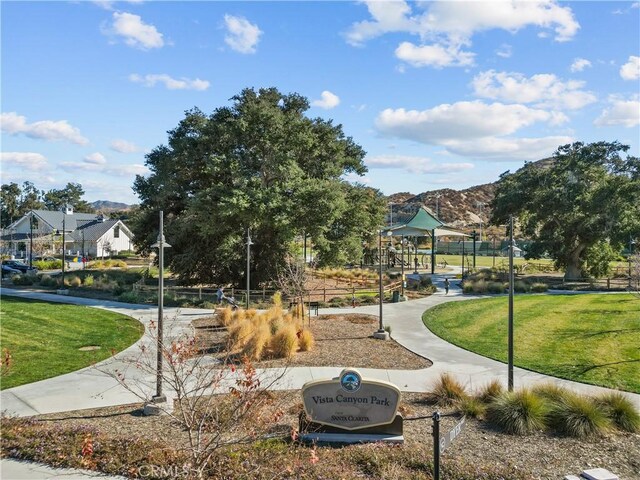 view of home's community featuring a playground, a mountain view, and a yard