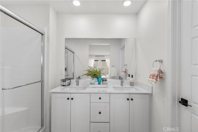 bathroom with a shower with door and vanity