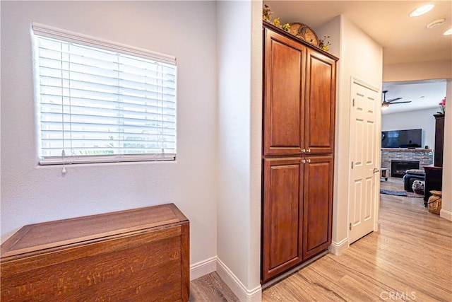 hall featuring a healthy amount of sunlight and light hardwood / wood-style flooring