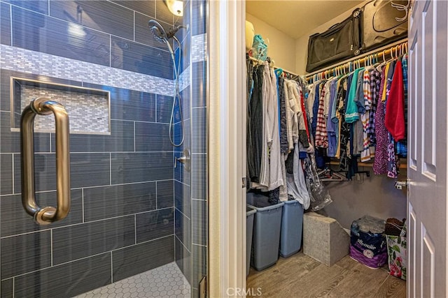 bathroom featuring a shower with shower door and wood-type flooring