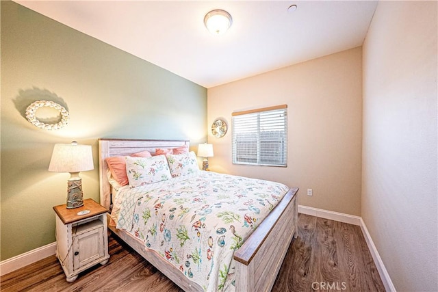 bedroom with dark hardwood / wood-style flooring