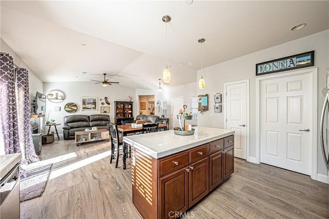 kitchen with lofted ceiling, decorative light fixtures, tile countertops, light wood-type flooring, and ceiling fan