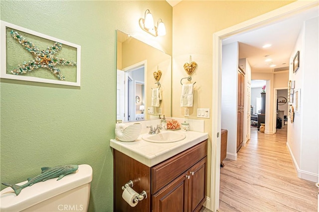 bathroom featuring toilet, hardwood / wood-style floors, and vanity