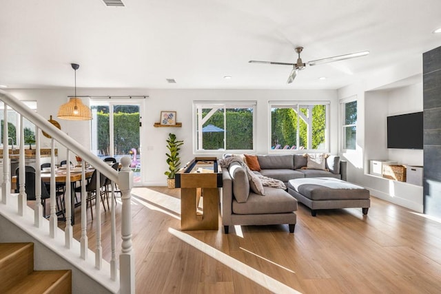 living room with ceiling fan and light wood-type flooring