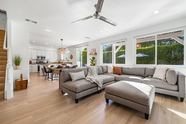 living room with light hardwood / wood-style floors and ceiling fan