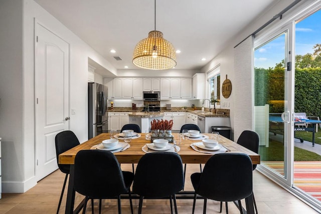 dining area featuring sink and light hardwood / wood-style flooring