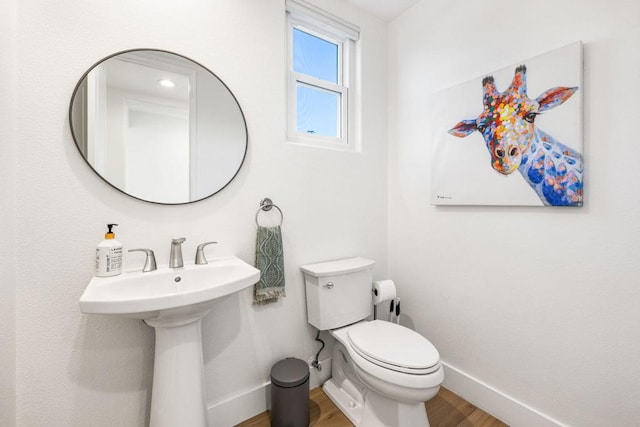 bathroom with toilet and hardwood / wood-style floors