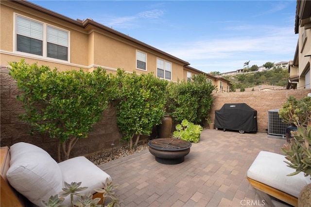 view of patio featuring a fire pit, area for grilling, and central AC