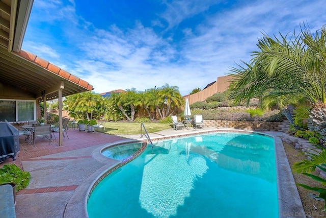 view of pool featuring grilling area, a patio area, and an in ground hot tub