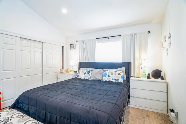 bedroom with carpet floors, a closet, and vaulted ceiling