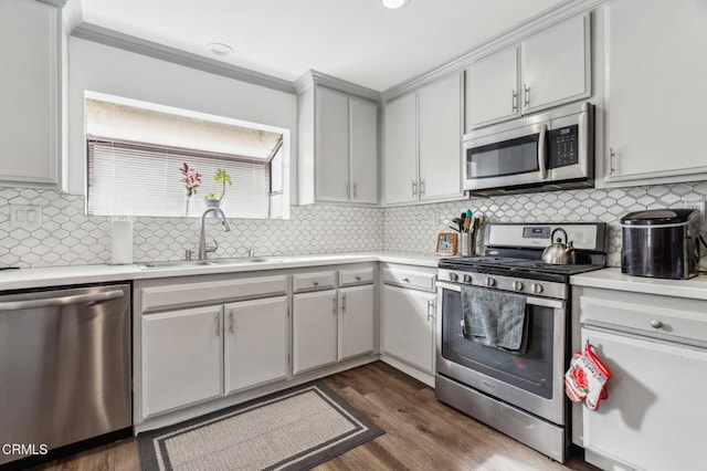 kitchen featuring tasteful backsplash, sink, stainless steel appliances, white cabinets, and dark hardwood / wood-style flooring