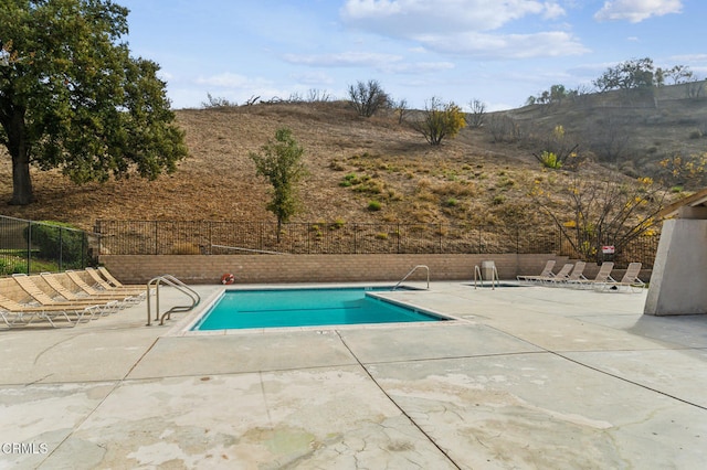 view of pool featuring a mountain view and a patio