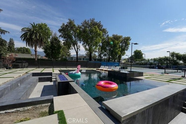 view of pool with tennis court