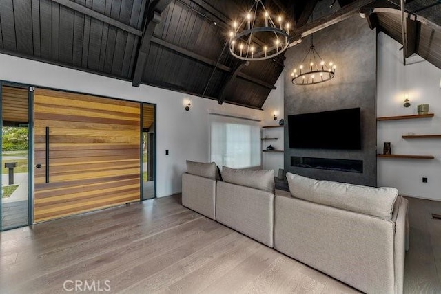 unfurnished living room with a fireplace, hardwood / wood-style flooring, a chandelier, high vaulted ceiling, and beam ceiling