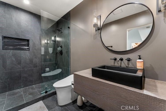 bathroom featuring sink, tile patterned floors, toilet, and tiled shower