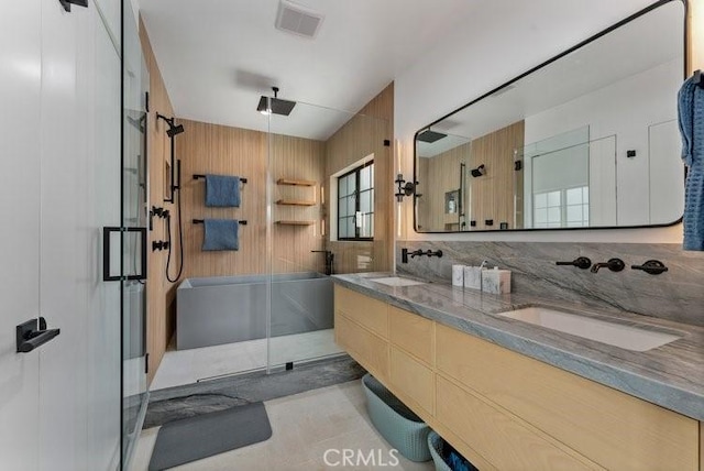 bathroom with a shower with shower door, vanity, and tile patterned flooring