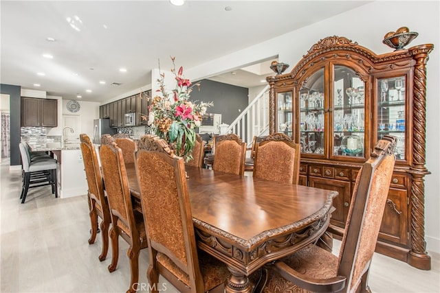 dining space with light hardwood / wood-style flooring and sink