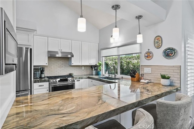 kitchen with pendant lighting, white cabinets, stainless steel appliances, a kitchen breakfast bar, and kitchen peninsula