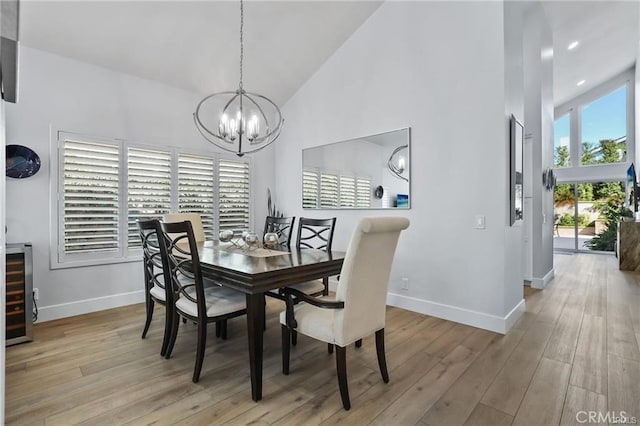 dining area featuring high vaulted ceiling, a wealth of natural light, beverage cooler, and light hardwood / wood-style flooring