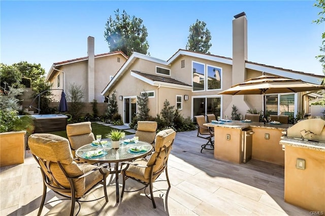 rear view of property featuring exterior kitchen and a patio area