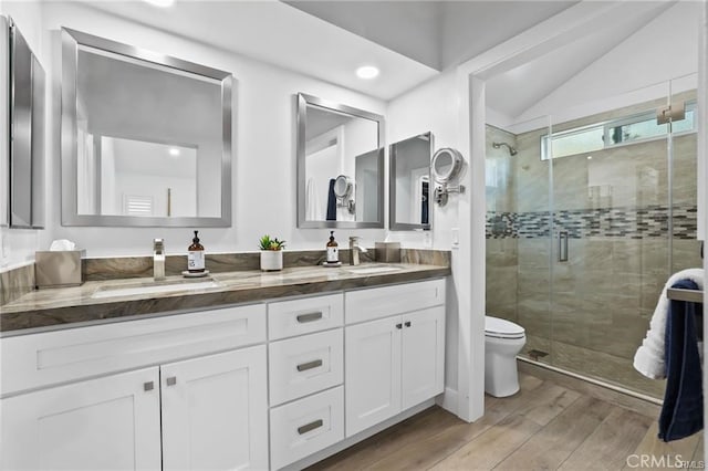 bathroom featuring a shower with shower door, toilet, vanity, and lofted ceiling