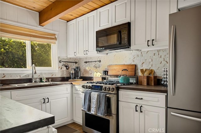 kitchen featuring sink, beamed ceiling, stainless steel appliances, white cabinets, and wooden ceiling