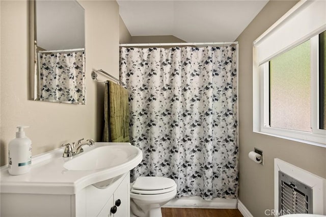 bathroom with hardwood / wood-style floors, lofted ceiling, vanity, toilet, and a shower with shower curtain