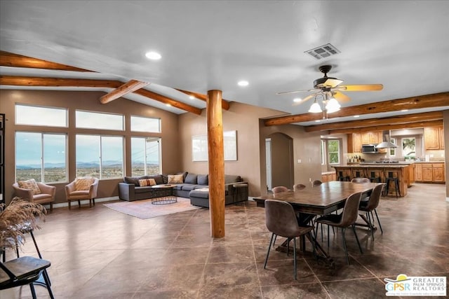 dining space with ceiling fan and vaulted ceiling with beams