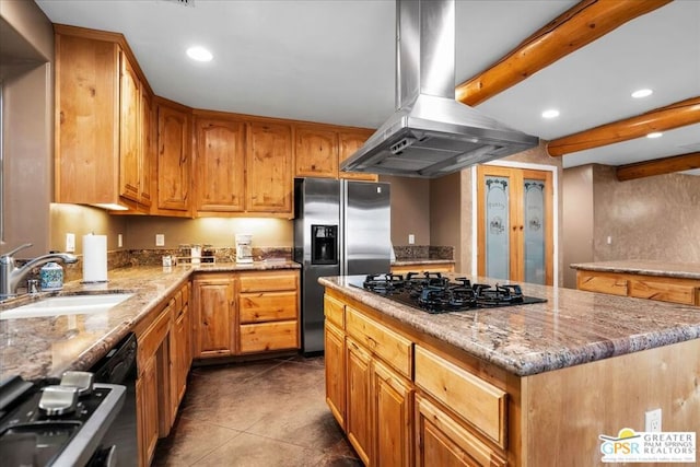 kitchen with stainless steel fridge, island exhaust hood, black gas cooktop, a kitchen island, and sink