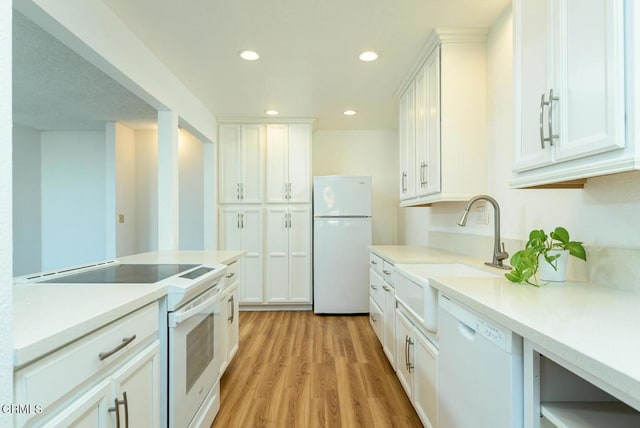 kitchen featuring light hardwood / wood-style floors, sink, white appliances, and white cabinets