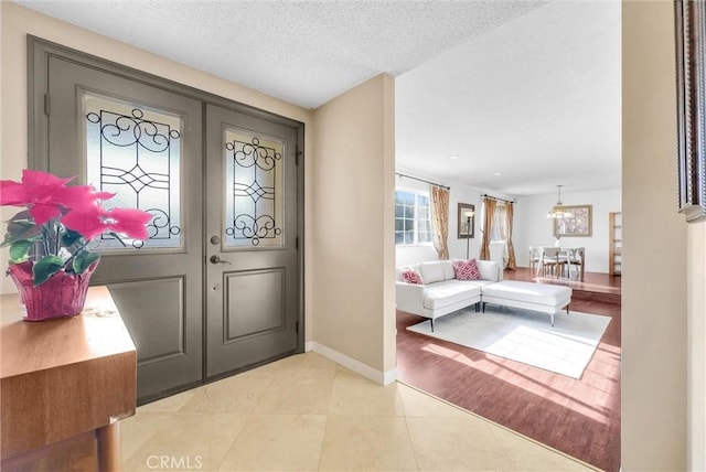 foyer with french doors, light tile patterned flooring, and a textured ceiling