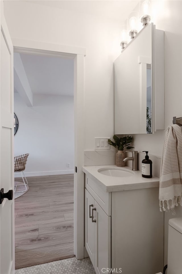 bathroom with wood-type flooring, toilet, and vanity