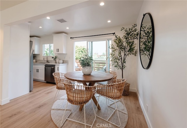 dining area with sink and light hardwood / wood-style flooring