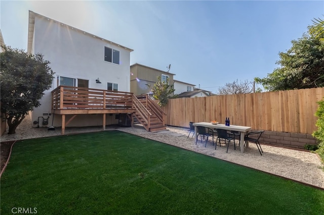 rear view of house featuring a deck and a lawn