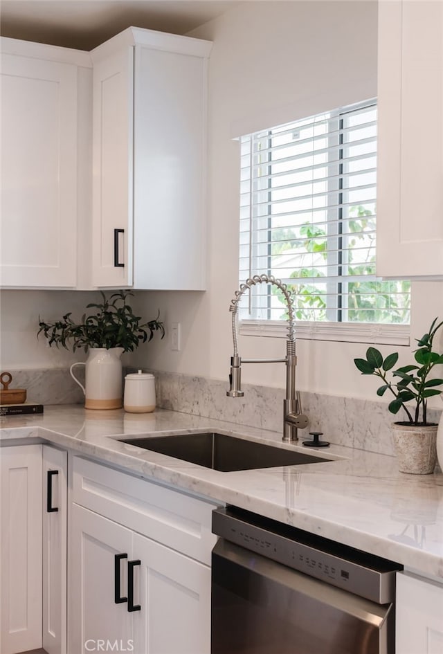 kitchen with sink, white cabinets, stainless steel dishwasher, and a healthy amount of sunlight