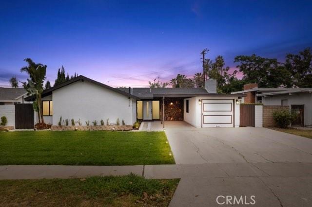 single story home with a garage and a yard