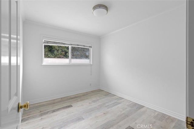 spare room with light hardwood / wood-style flooring and crown molding