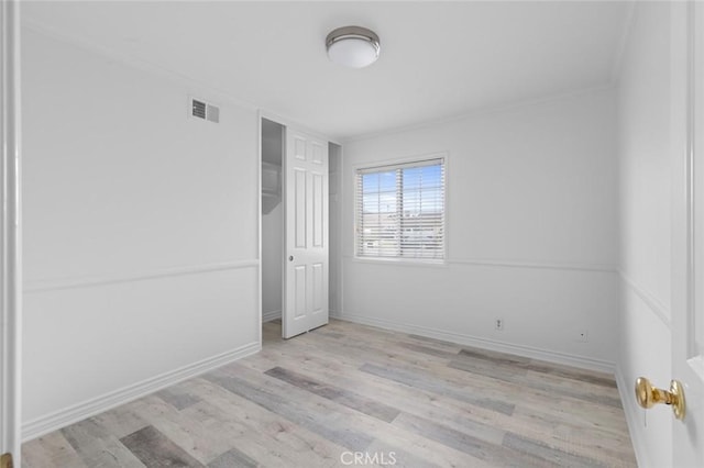 unfurnished bedroom featuring light wood-type flooring and crown molding