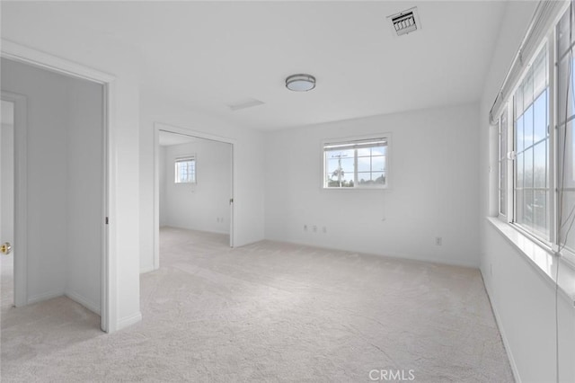 empty room with light colored carpet and plenty of natural light