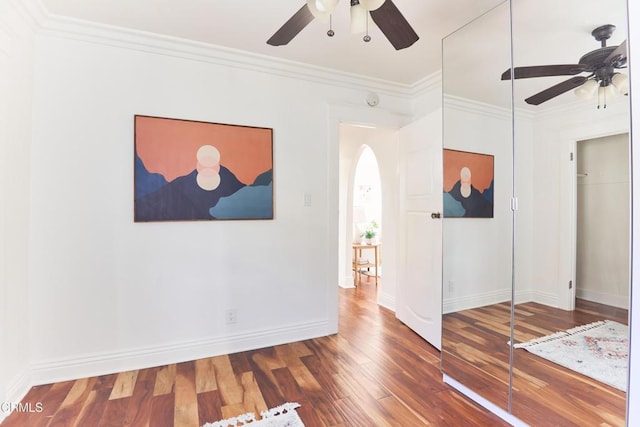 empty room featuring ceiling fan, crown molding, and hardwood / wood-style floors