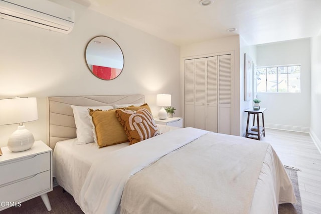 bedroom with a closet, dark wood-type flooring, and a wall mounted air conditioner