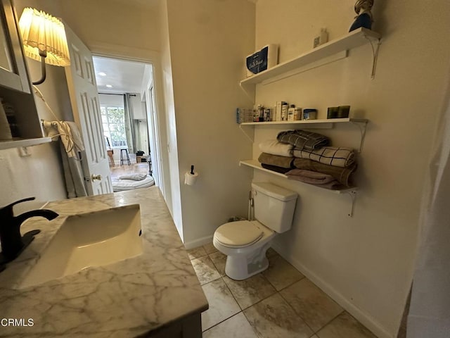 bathroom with toilet, tile patterned floors, and vanity