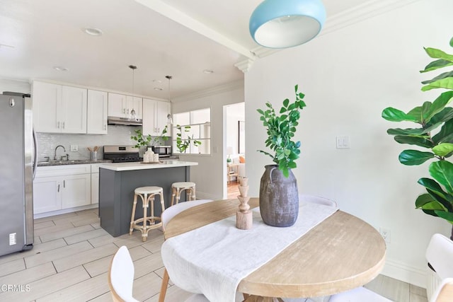 dining room with sink and ornamental molding