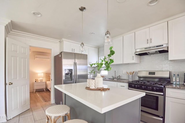 kitchen featuring a wall mounted AC, sink, hanging light fixtures, appliances with stainless steel finishes, and white cabinets