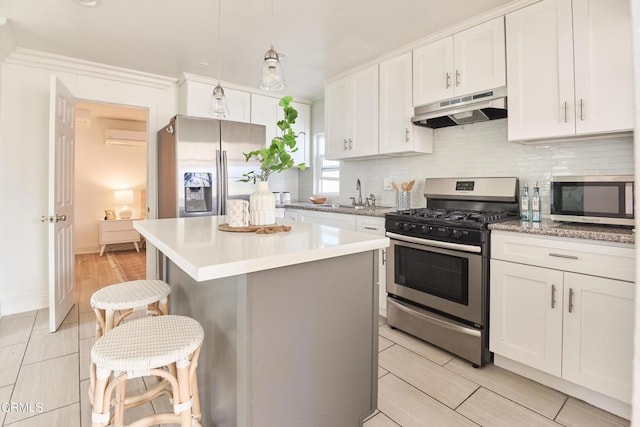 kitchen featuring white cabinets, stainless steel appliances, and a kitchen island